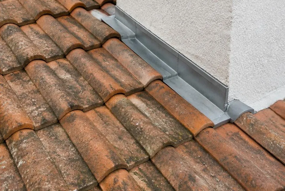 Tuiles cassées et solin dégradé près d'un mur puis tuiles remplacées et solin neuf — après