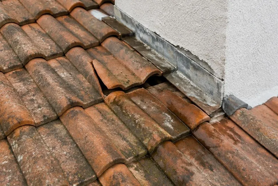 Tuiles cassées et solin dégradé près d'un mur puis tuiles remplacées et solin neuf — avant
