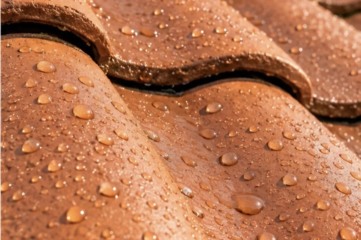 Tuiles en terre cuite qui absorbent la pluie, puis tuiles traitées hydrofuge sur lesquelles l'eau perle — après